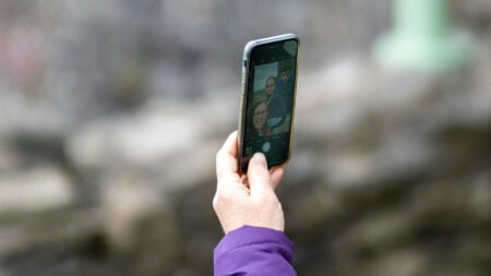 ‘No Need to Be Rude! We’re Geocaching!’: New York Homeowner Says They Were Scolded After Confronting Trespassing Mother With Kids Woman taking a selfie out in a forested area