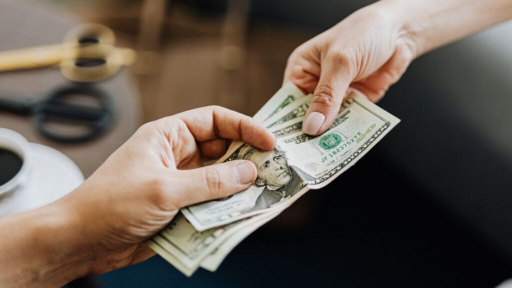 A $6,000 Raise Became Only $47 More Per Paycheck, So Where Did the Money Go? People handing each other dollar bills