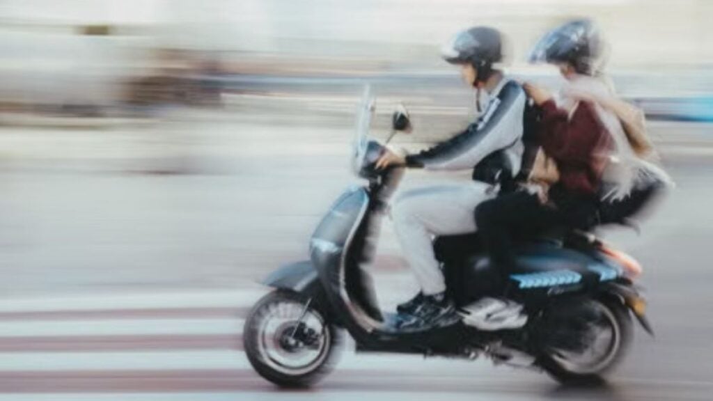 Maryland Teen Takeover Takes Wild Turn as Two Girls Crash Scooter Through Restaurant Window: ‘They Will Be Voters in 2028’ Motion-blurred image of two people riding a scooter through a city street in Rabat, Morocco.