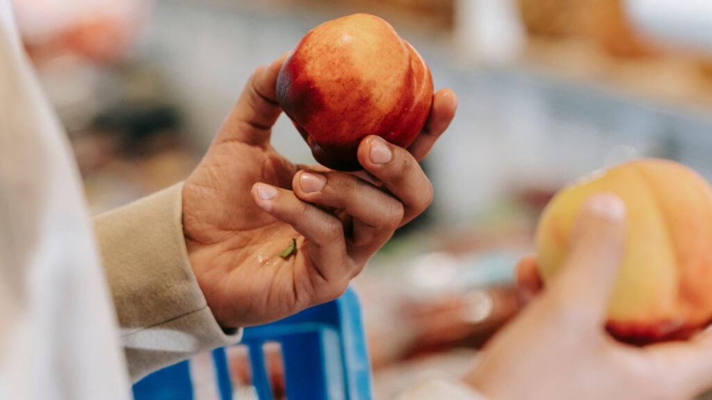Colorado Whole Foods Shopper Says Staff Gaslit Them Over a $1 Peach: ‘He Spoke to Me Like I Was an Idiot’ Person holding peaches in their hands