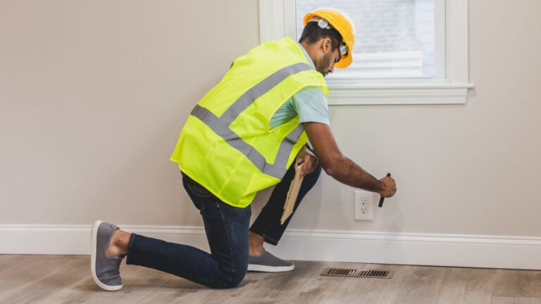 Connecticut Woman Says Landlady Dared Her to Report Her to the City, So She Did: ‘Sounds Good to Me!’ A home inspector in high visibility vest examines an electrical outlet in a modern room