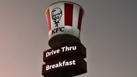 KFC drive-thru sign under a half moon at twilight in Midrand, South Africa.