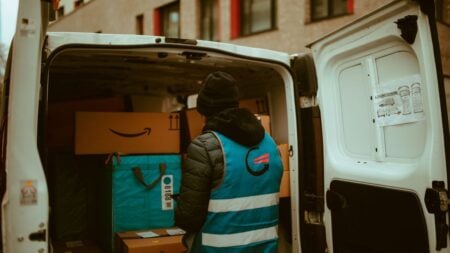 ‘Yeah Customers Like That Don’t Get a Delivery’: Maryland Amazon Driver Slams Customer’s 350-Foot Delivery Request A delivery worker in a reflective vest loads packages into a van.