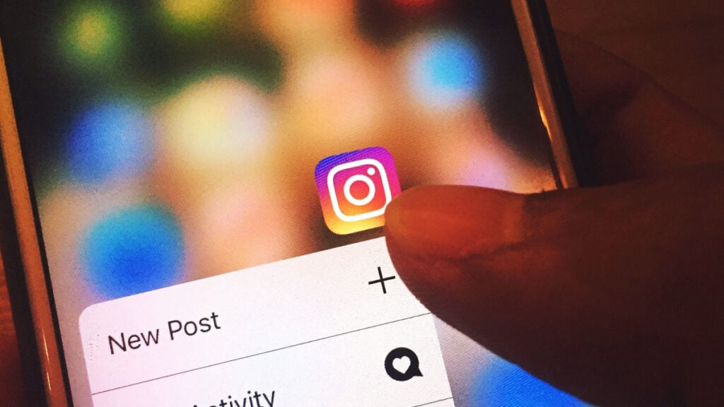 Think Before You Post: Federal Agents Are Increasingly Pursuing Online Threats Finger navigating Instagram app on a smartphone screen
