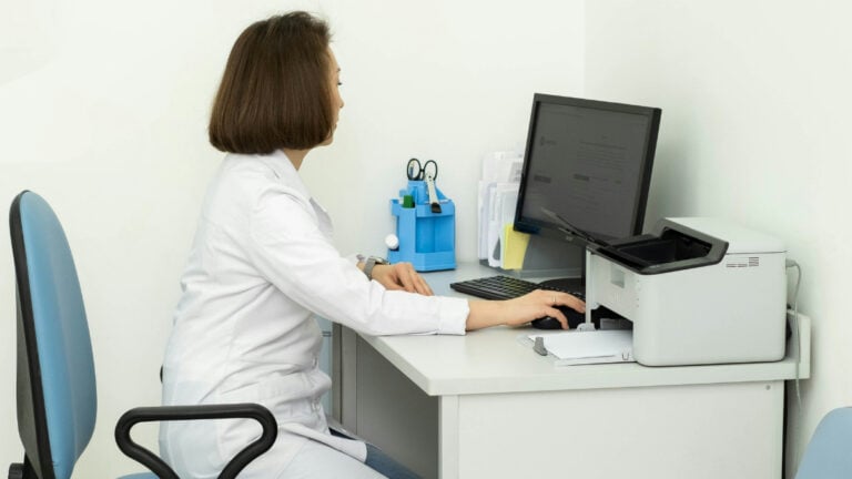 Healthcare worker at a desk working with a computer