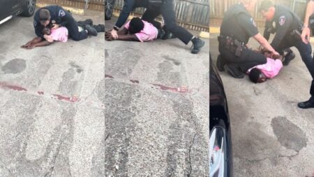 A man being pinned down by a police officer.