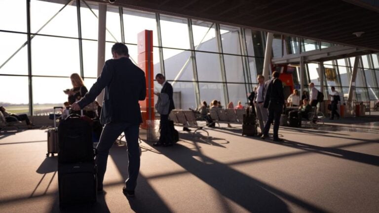Colorado Airport Argument Goes Off the Rails After Passenger Uses Racial Slur: ‘Bro Forgot He Wasn’t on Twitter’ Travelers in a bustling airport terminal with carry-on luggage waiting for departure.