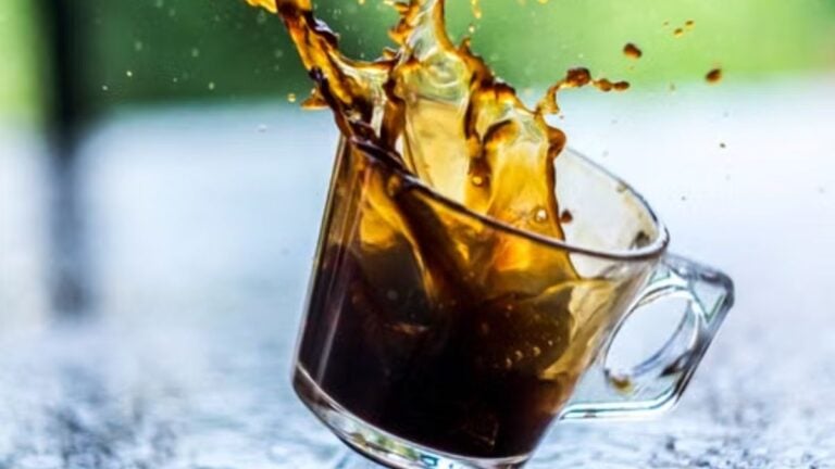 Internet Divided After Utah Husband Gets Aggressive With Teens as Wife Throws Iced Tea at Truck Over Speed Dispute: ‘Call the Police’ Capture of coffee splash in a transparent glass cup with a blurred background.