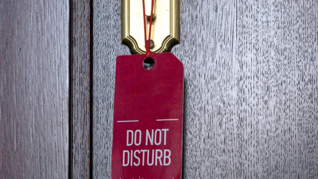 Terrified Kansas Hotel Guest Says She Awoke to Employee Sawing Through Her Locked Door: ‘More of a Complain-to-Corporate Type of Situation’ A door handle with a do not disturb sign