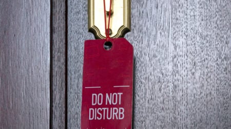 Terrified Kansas Hotel Guest Says She Awoke to Employee Sawing Through Her Locked Door: ‘More of a Complain-to-Corporate Type of Situation’ A door handle with a do not disturb sign