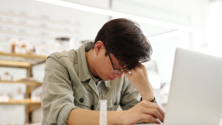 California Worker Says Employer’s Payroll Mistake Drained His Savings and Left Checking Account at Negative $3,200: ‘They Robbed You’ Exhausted young man working on a laptop