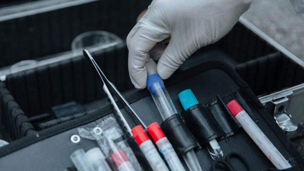 Centuries-Old Forensic Test Helped Convict Woman of Murder, but Officials Now Question Its Use Gloved hand handling test tube in forensic equipment case
