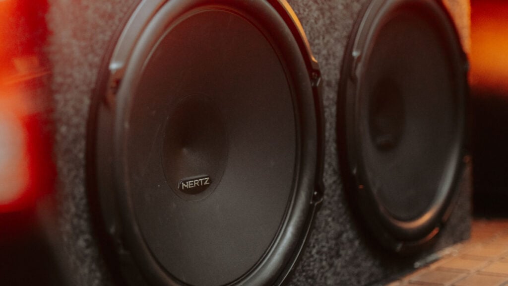 Utah Resident Says Neighbor Blasts 700-Watt Speaker Day in and Day Out: ‘Cops Say It’s Totally Legal Until 10:30 PM’ Close-up of dual subwoofers in a car trunk with glowing lights