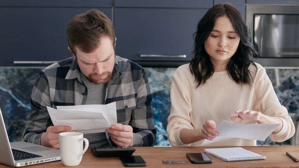 ‘Charge Elon More!’: Memphis Gas and Water Bills Could Climb $28 a Month as Tennessee Residents Push Back A couple reviews bills and manages finances on a kitchen table, looking concerned.