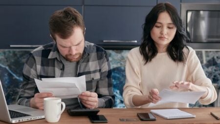 ‘Charge Elon More!’: Memphis Gas and Water Bills Could Climb $28 a Month as Tennessee Residents Push Back A couple reviews bills and manages finances on a kitchen table, looking concerned.