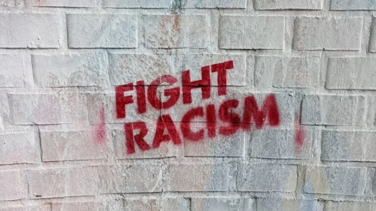 Graffiti on a brick wall in Hamburg, Germany, with the message 'Fight Racism.'