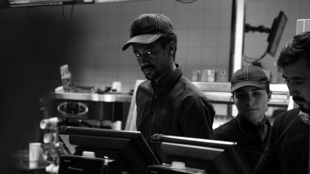 ‘I’m Sick of Them Treating Us Like Disposable Garbage’: Connecticut Restaurant Worker Says Warning New Employee About Low-Paying Shifts Got Her Fired Black and white image of fast food employees behind the counter